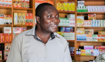 A pharmacist in his drugstore in Ghana A pharmacist and his son welcoming a client in a drugstore in Ghana